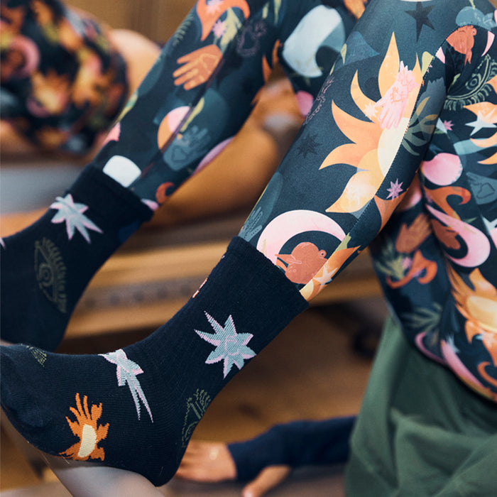 Black cotton Element crew socks with sun and star prints, styled with matching multi-coloured leggings.