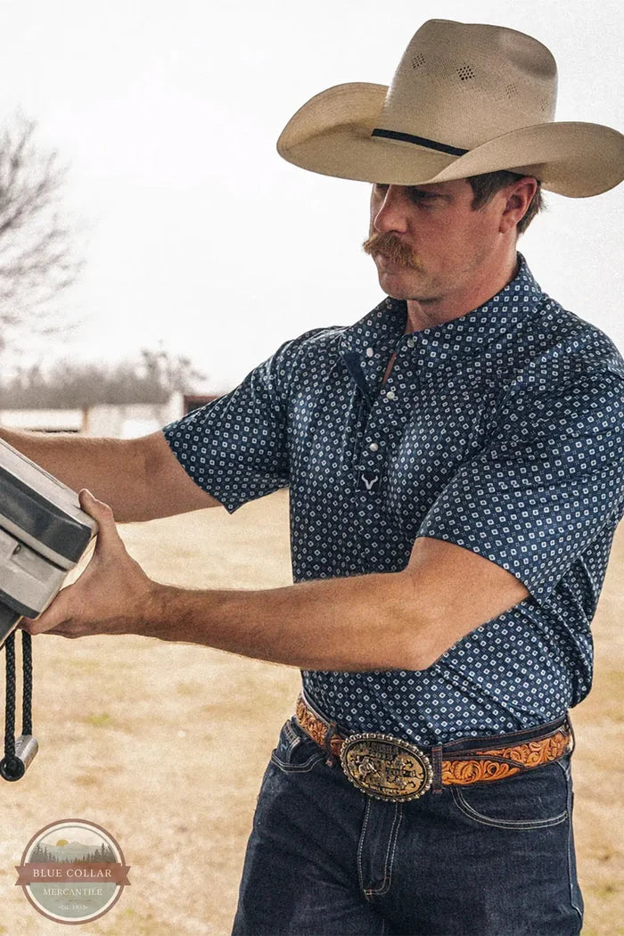 Vexil Brand – Western Pearl Snap Polo - Tribal Board | Navy lifestyle image of cowboy working in Vexil Polo